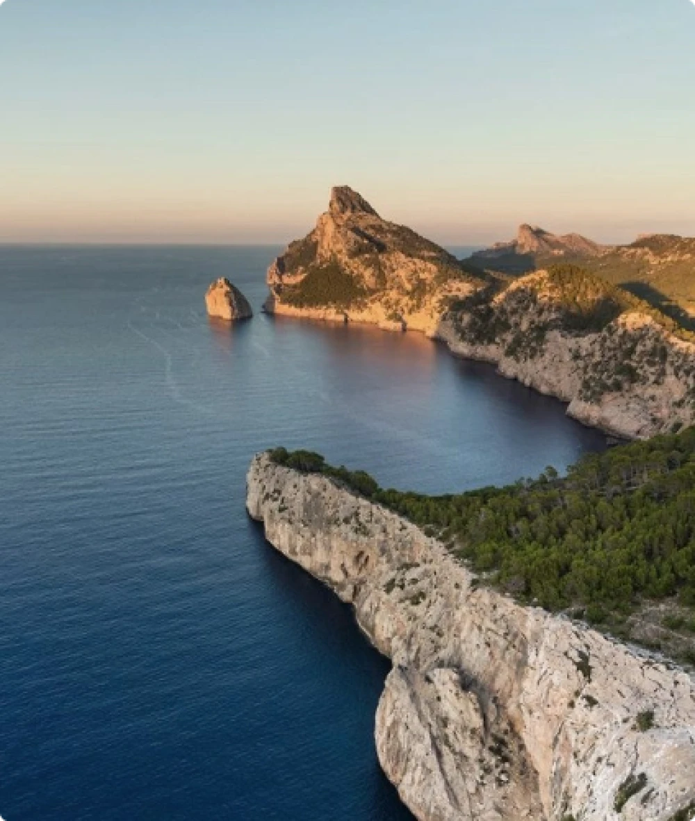 Una cala costera con una puesta de sol