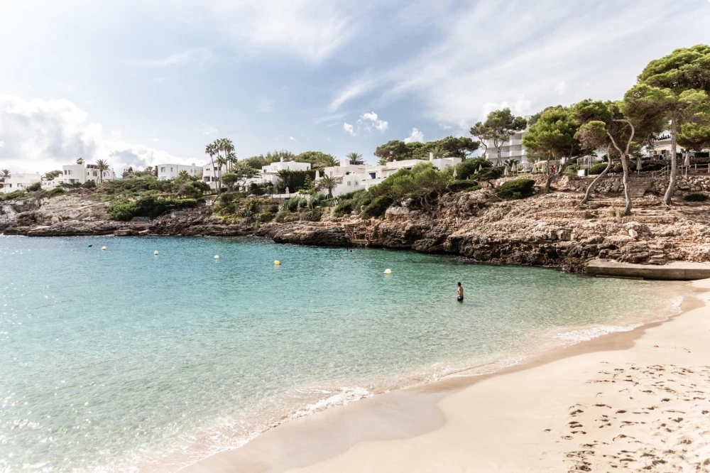 Una playa de arena con aguas cristalinas.